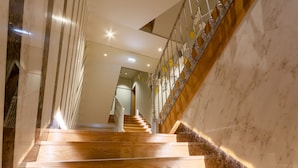 Un escalier en marbre avec des marches en bois et une rampe en métal.