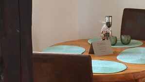 A dining table with placemats, a lamp, and a small decorative item.
