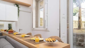 A breakfast setup with a wooden table, breakfast items, and a view of the outdoors.