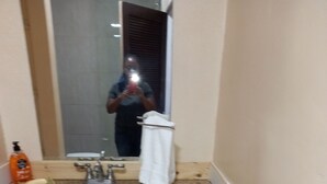 Une salle de bain avec un meuble-lavabo en bois, un évier et un miroir.