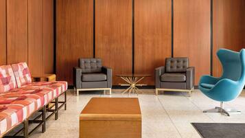 A modern living room with a sofa, two armchairs, a coffee table, and a patterned rug.