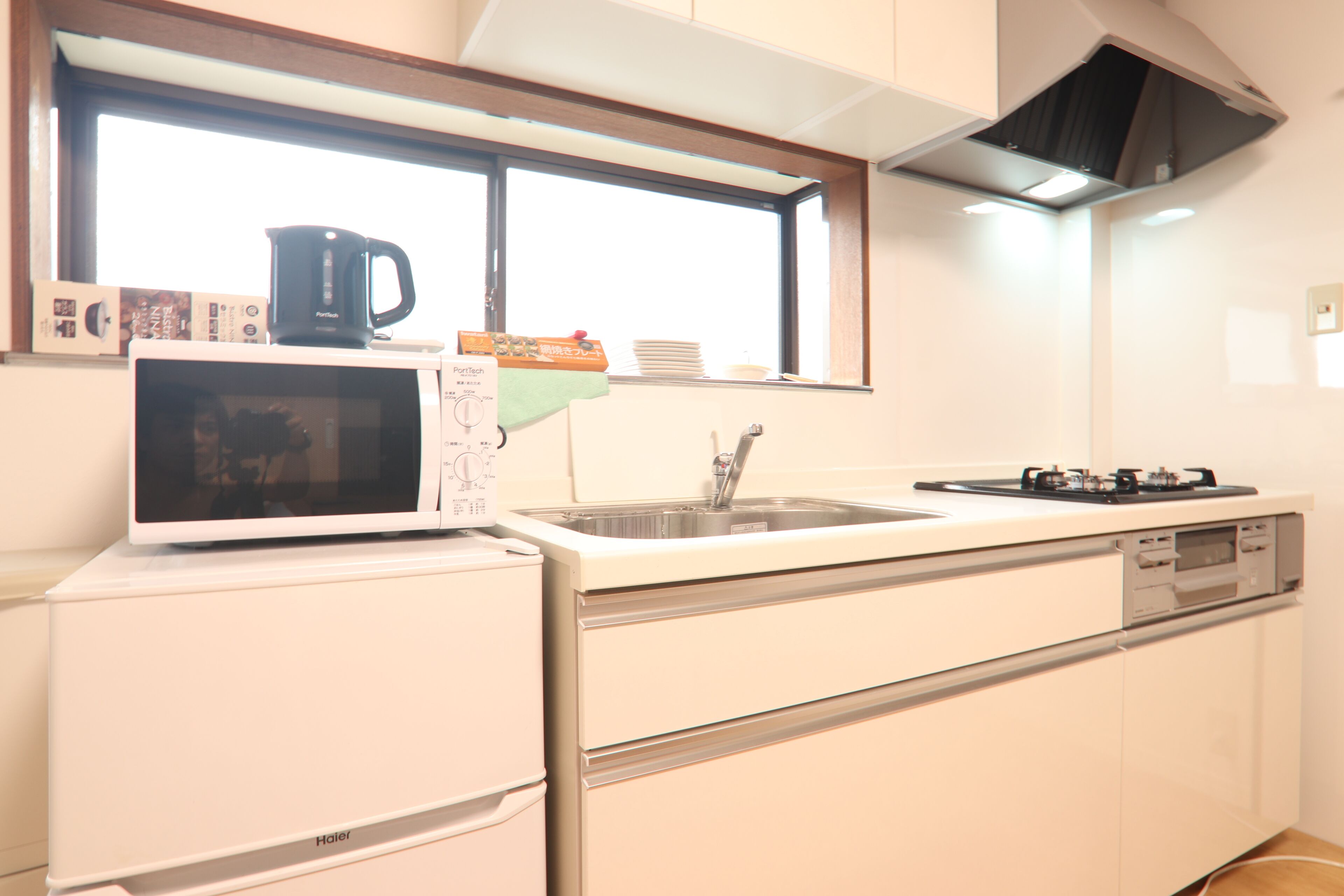 A kitchen with a microwave, sink, and stove.
