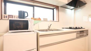 A kitchen with a microwave, sink, and stove.