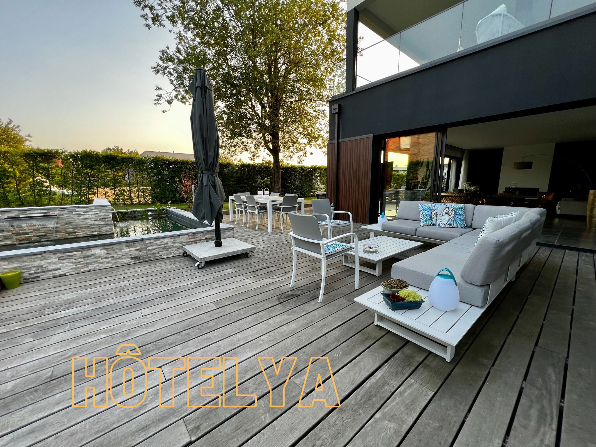 Un patio moderno al aire libre con piscina, zona de estar y vistas a un edificio.