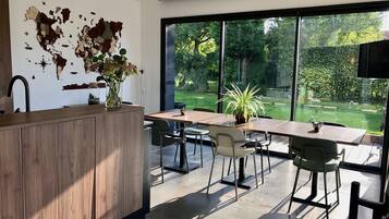 Une cuisine moderne dotée d’une grande fenêtre, d’une décoration représentant une carte du monde, et d’un coin repas avec des chaises et une table.