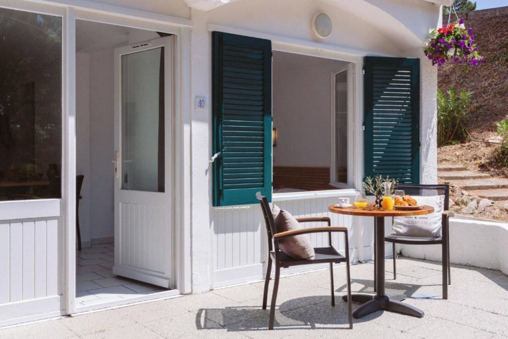 A room with a sliding door, a table with breakfast items, and a chair.