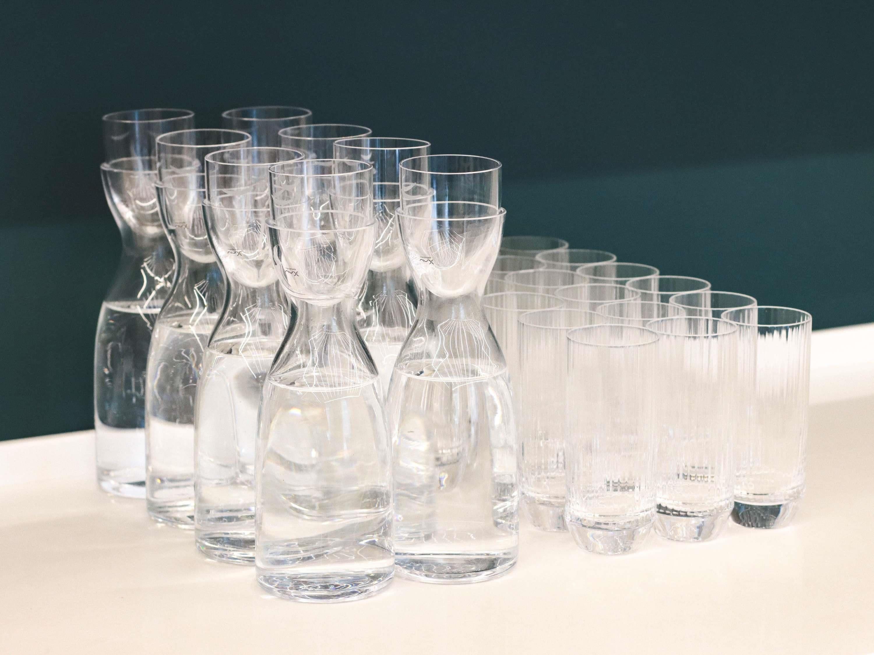 A collection of clear glassware, including vases and glasses, arranged on a table.