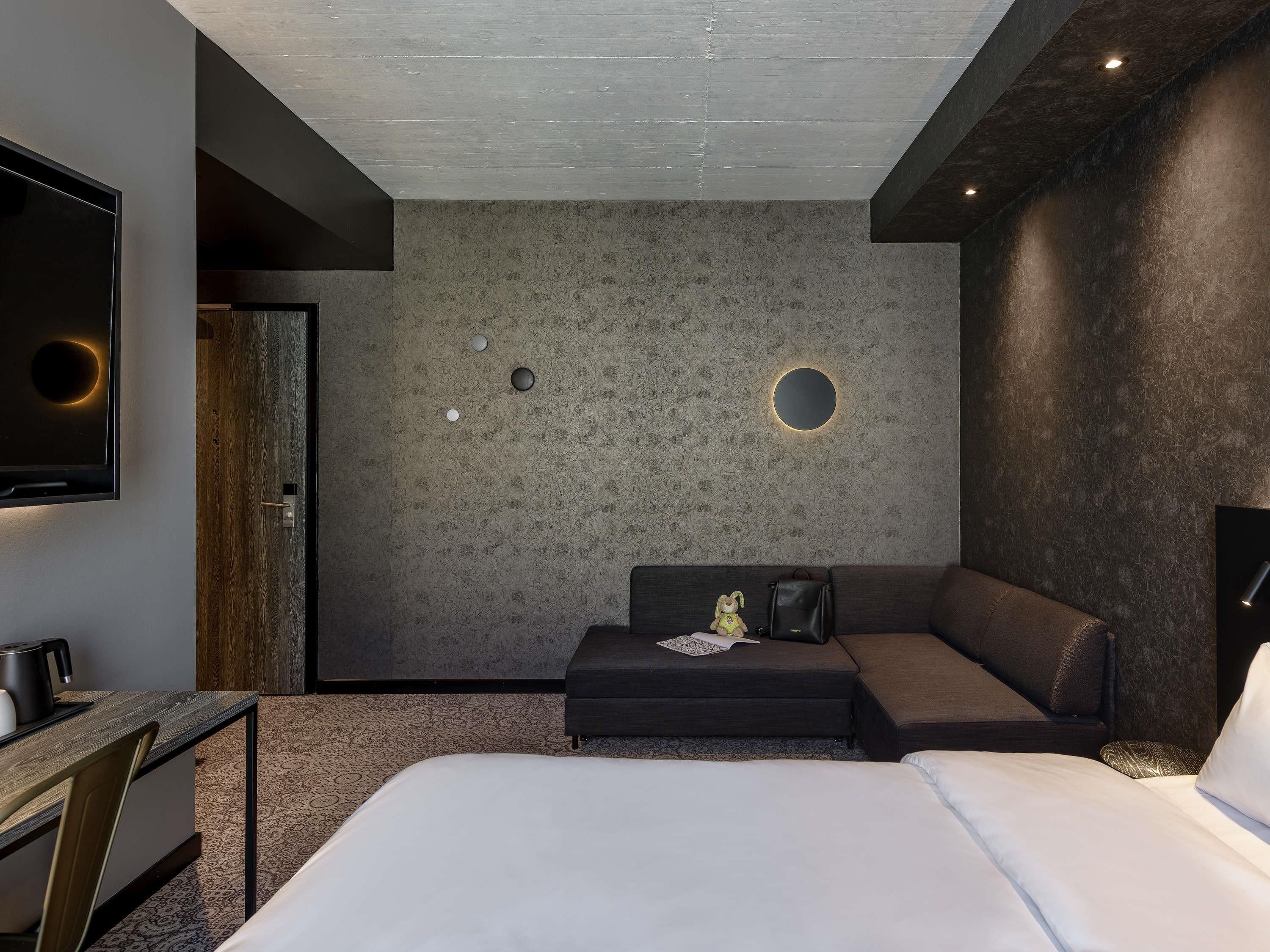 Une chambre d’hôtel moderne, dotée d’un grand lit, d’un bureau et d’un coin salon.