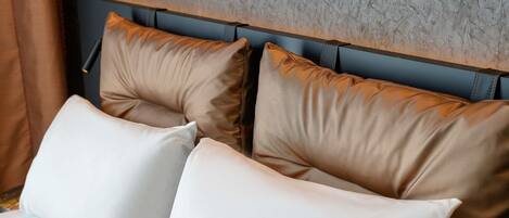 Una cama con cabecera frente a una pared con textura.