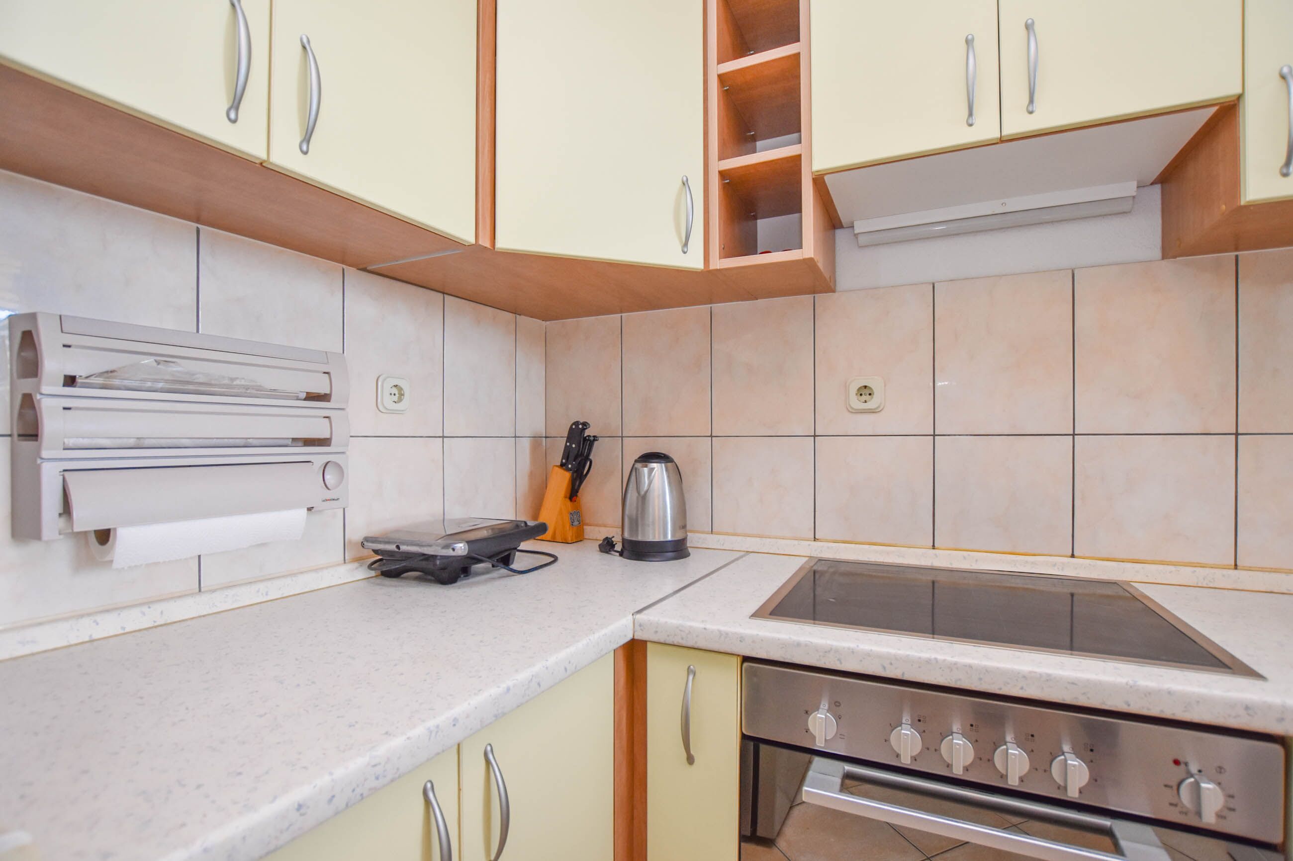A kitchen with a built-in oven, a stovetop, and a sink.