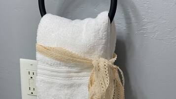 Tina con regadera, secadora de cabello, toallas, jabón