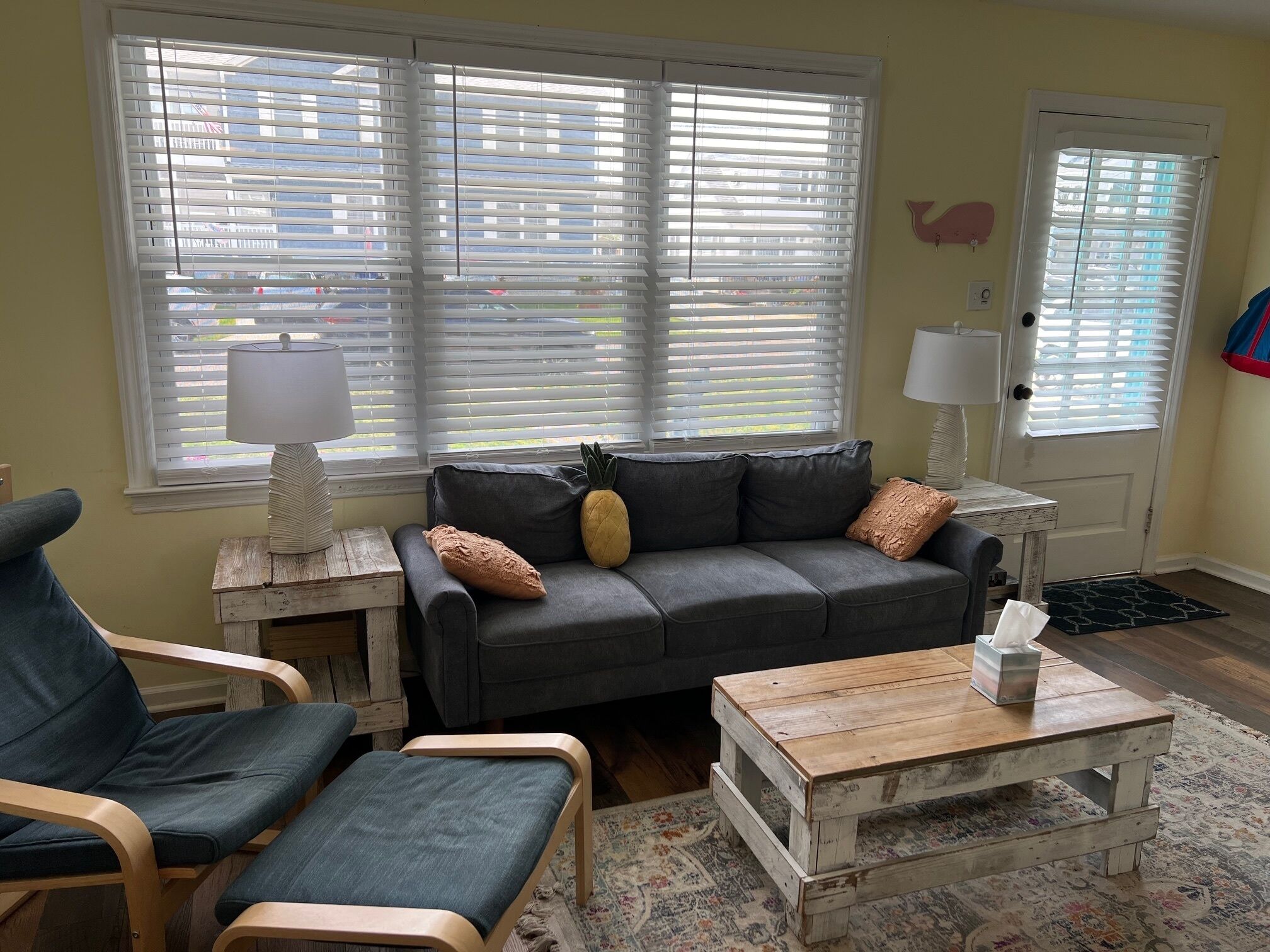 A living room with a grey sofa, wooden coffee table, and a blue armchair.