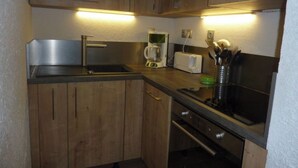 A compact kitchen with wooden cabinets, a stainless steel sink, a coffee maker, and a toaster. - T3 PRA LOUP 56 M2 Magnificent valley and mountain views 2 bedrooms (Uvernet-Fours)