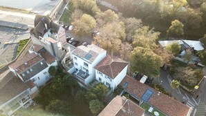An aerial view of a residential area with a mix of modern and traditional architecture, including a prominent building with a red and white striped awning. - UNIQUE VIEW TOUR DE LA LANTERNE Apartment WITH TERRACE 2-4 PERS. (La Rochelle)