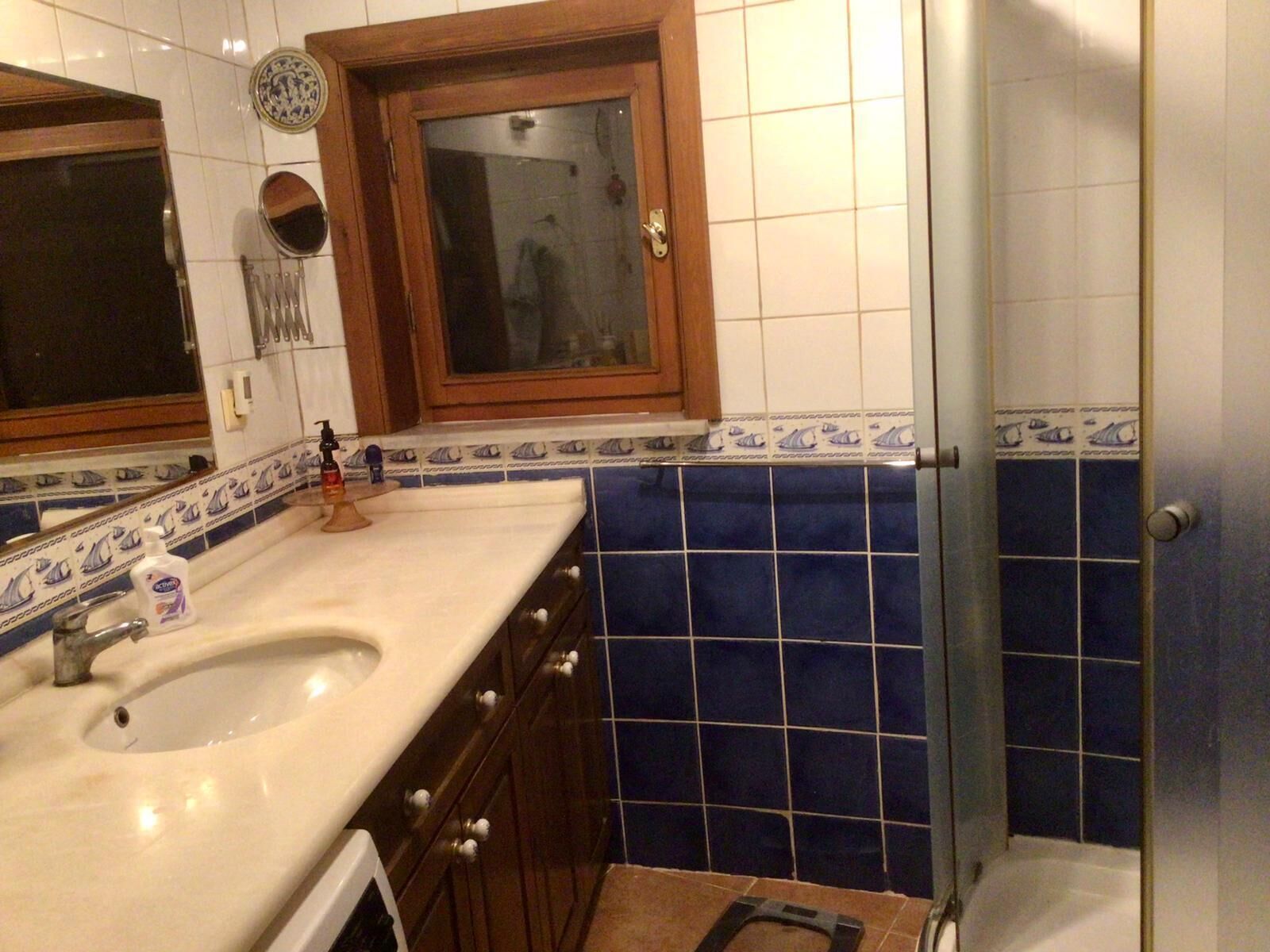 A bathroom with a sink, mirror, and shower.