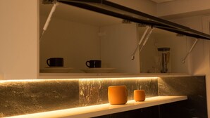 A kitchen with a countertop, a sink, and a mirror above it. - Incrível Suíte no Manaíra Apart Hotel (João Pessoa)