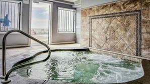 Spaområde med jacuzzi, udsigt til stranden og et vindue med havudsigt.