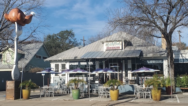 Un restaurant doté d’une terrasse, une enseigne indiquant « Heritage Park Bar & Grill », et une grande sculpture de tortue.