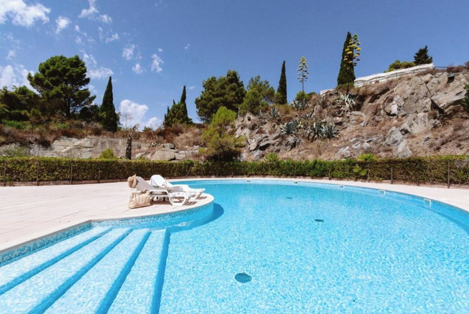 Une piscine dotée de chaises longues et offrant une vue dégagée sur le paysage environnant.