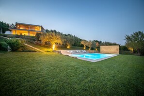 Une maison moderne dotée d’une piscine et d’une pelouse bien entretenue.