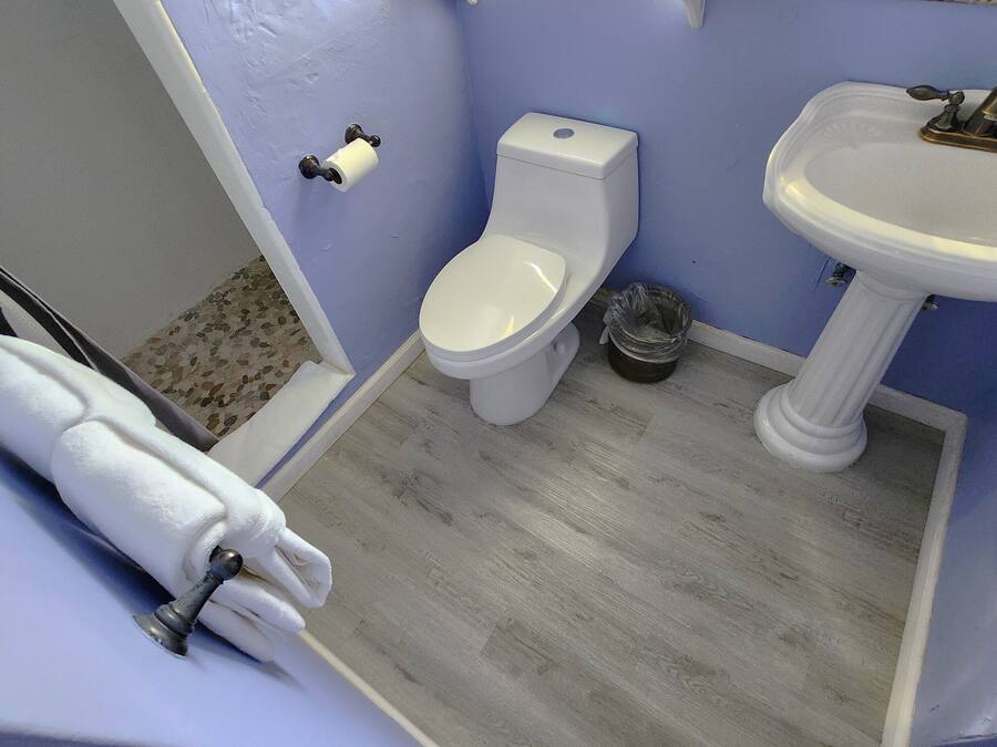 A bathroom with a toilet, sink, and a towel rack.