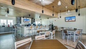 A spacious indoor dining area with wooden flooring, white walls, and a variety of seating options including tables and chairs. - Beautiful & Beachy!
3BR Townhome Lost Key Golf & Beach Club, Pools, Free Shuttle (Pensacola)