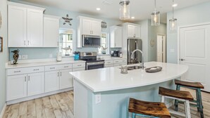A modern kitchen with white cabinets, a large island, stainless steel appliances, and pendant lighting. - Beautiful & Beachy!
3BR Townhome Lost Key Golf & Beach Club, Pools, Free Shuttle (Pensacola)
