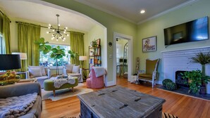 A living room with a sofa, armchair, coffee table, and a fireplace.