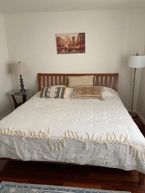 A neatly made bed with a white duvet and patterned pillows, a wooden headboard, and a framed picture above it. - Lux 2 BR, 1,5 Ba TH 1/2 block to IB Beach! (Imperial Beach)