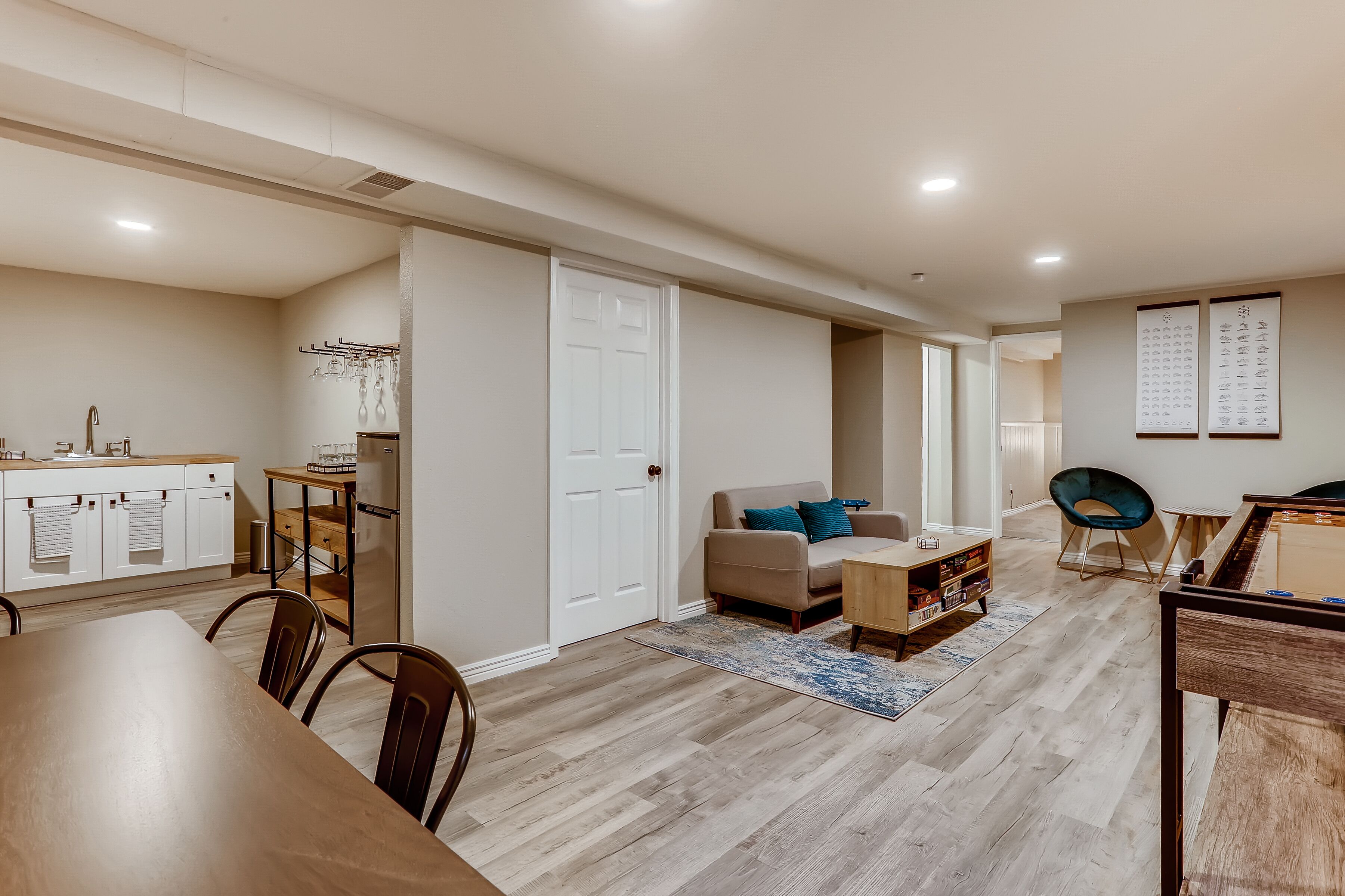 A spacious living area with a kitchen, dining table, and a pool table.