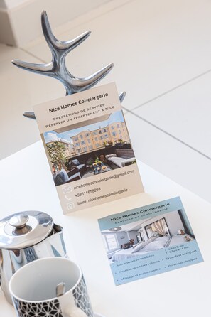 A brochure for Nice Homes Conciergerie with a photo of an outdoor seating area, contact information, and a list of services.