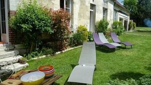 A backyard with a pool, lounge chairs, and a table with bowls. - Cozy Cottage (Éméville)