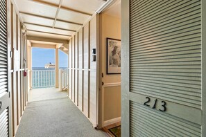 A corridor with a view of the sea and a building number 213.