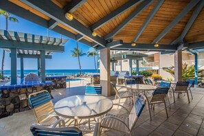 Ein Außenbereich mit Terrasse, Pool, Liegestühlen und einem Tisch.