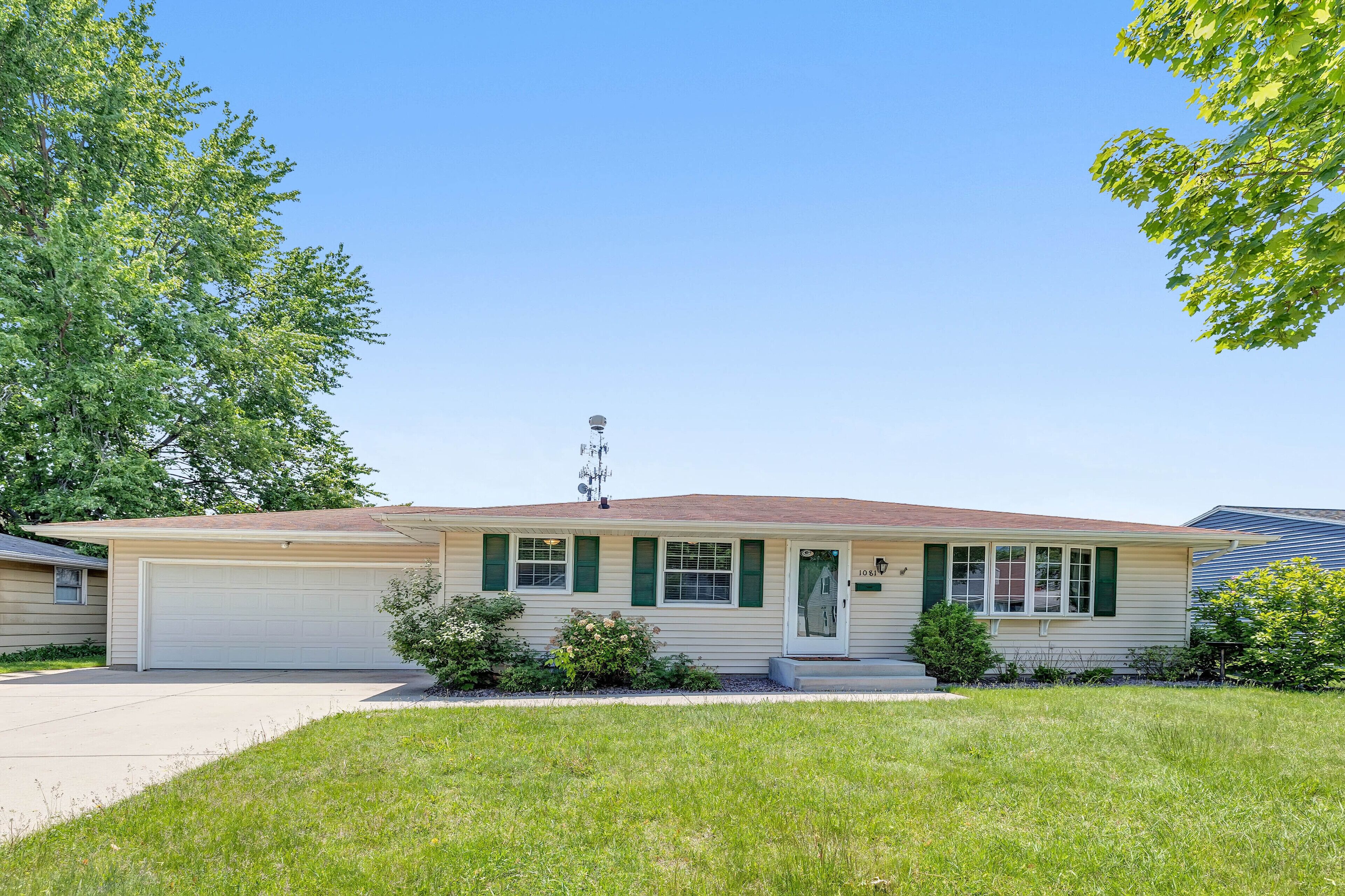 A single-story house with a garage, a front porch, and a small front yard.