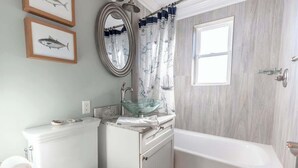 A bathroom with a toilet, sink, and bathtub. - Newport's favorite Neighborhood 3bed (Newport)