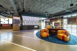 Un vestíbulo moderno con una gran pantalla digital, zona de estar y un cartel de Sports Illustrated Resorts.