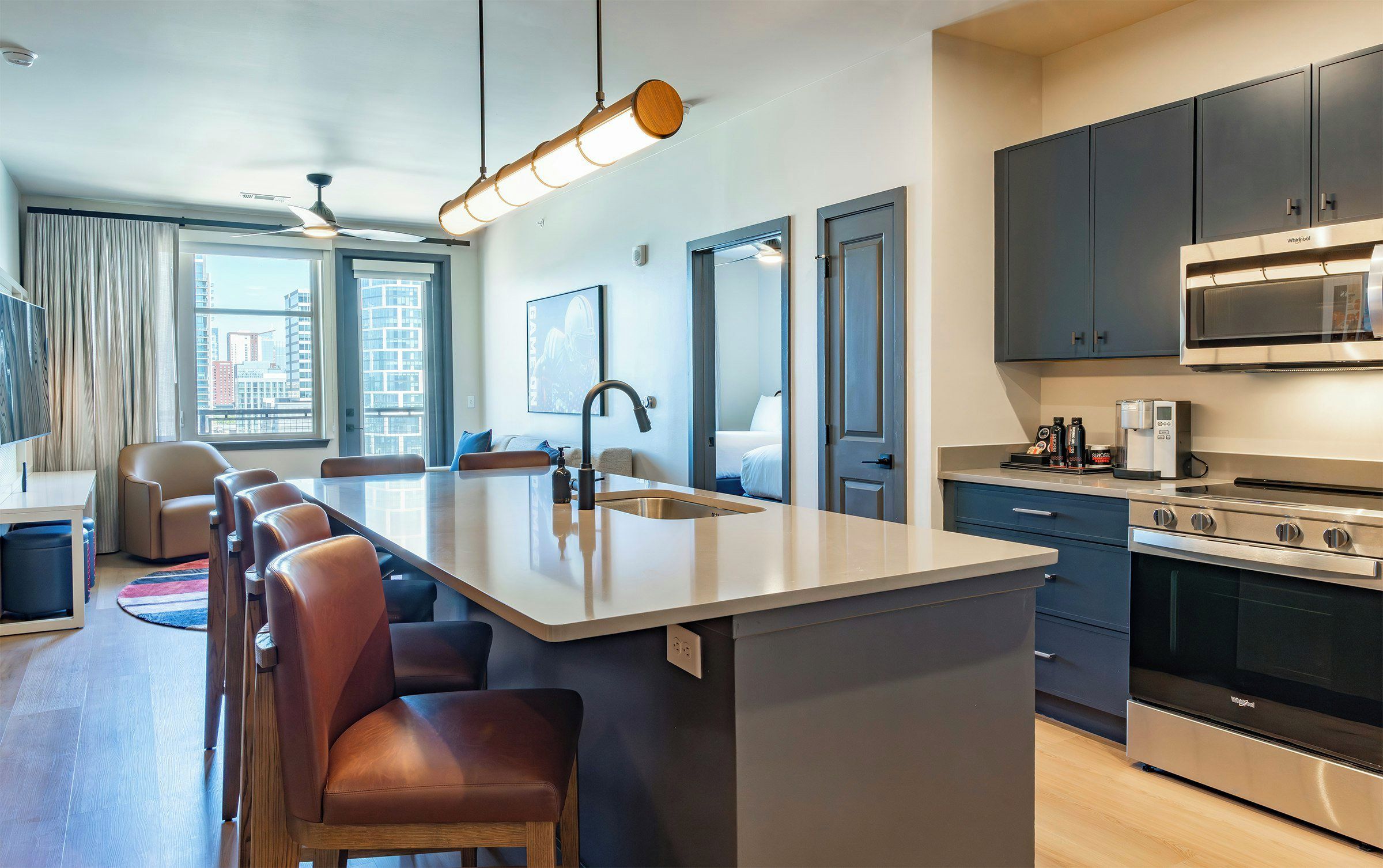 A modern kitchen with a central island, stainless steel appliances, and a view of the city.