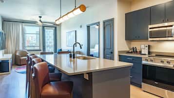 Una cocina moderna con una isla central, electrodomésticos de acero inoxidable y vistas a la ciudad.