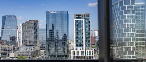 Un paisaje urbano con modernos rascacielos, incluyendo un imponente rascacielos de FirstBank.