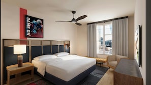 A hotel room with a bed, a desk, a chair, a ceiling fan, and a window with curtains. - Sports Illustrated Resorts Nashville (Nashville)
