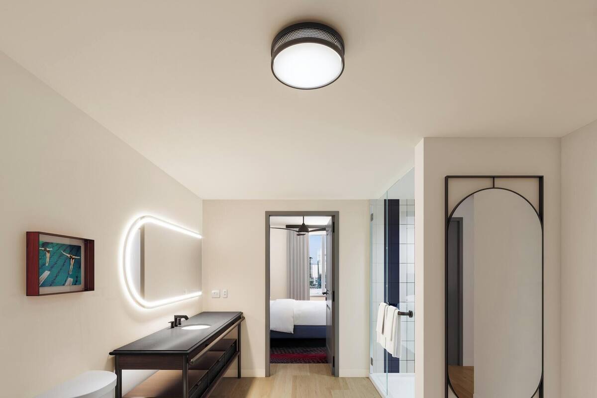 A modern bathroom with a toilet, sink, and mirror.