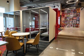 A modern office space with glass partitions, comfortable seating, and a wall adorned with sports magazines. - Sports Illustrated Resorts Nashville (Nashville)