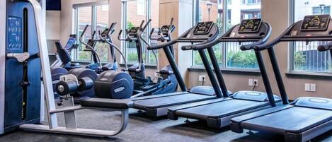 A gym with treadmills, elliptical machines, and weight equipment.