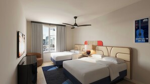 A hotel room with two beds, a ceiling fan, a window with curtains, a desk with a lamp, and a poster on the wall.