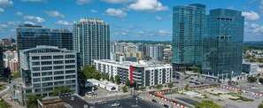 A high-rise building with a modern glass facade, surrounded by other buildings and a parking area. - Sports Illustrated Resorts Nashville (Nashville)