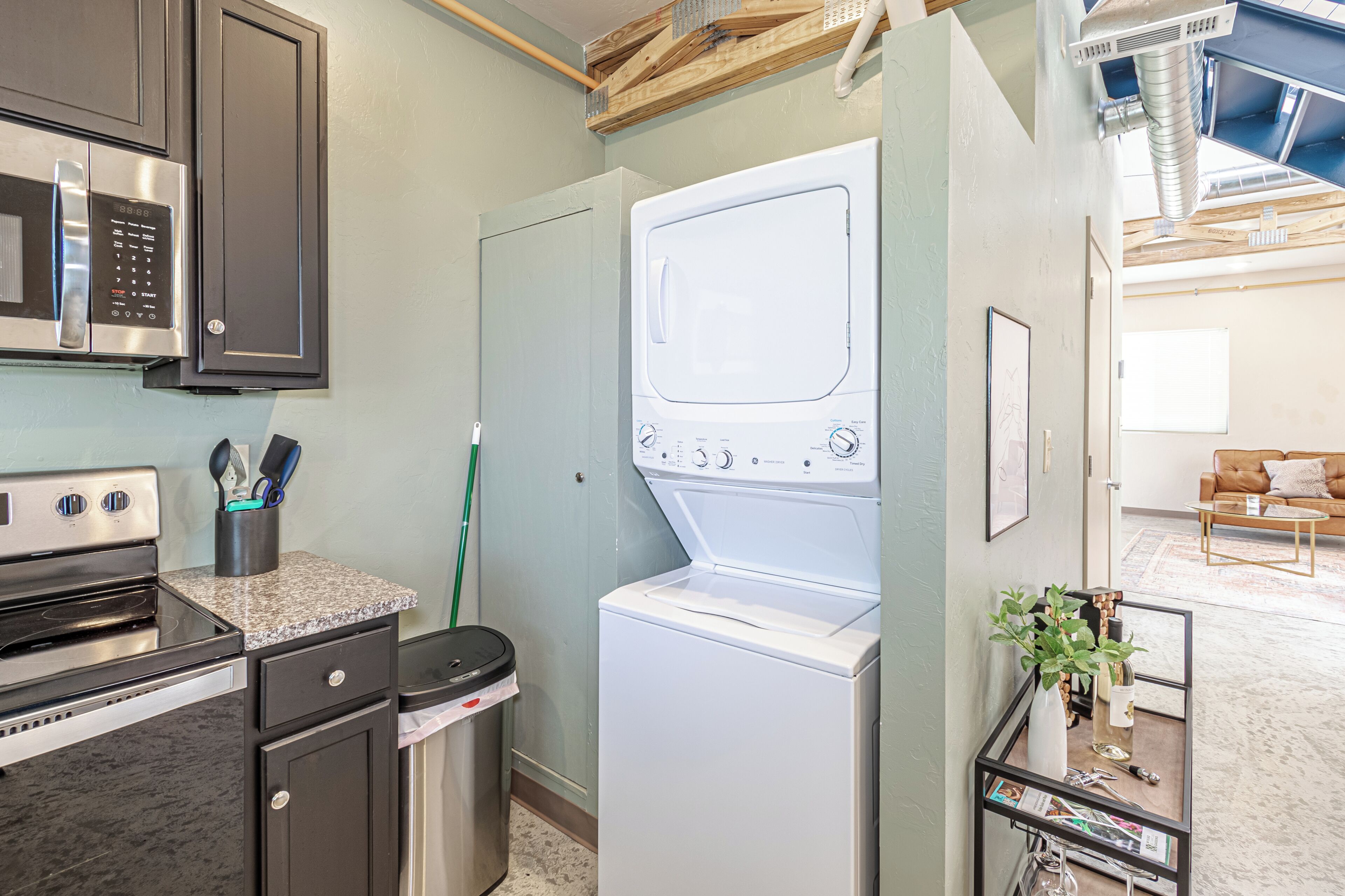 A laundry room with a washing machine, a microwave, and a stove.