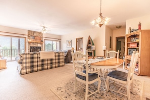 Cozy living area with a large sofa, dining table, and fireplace, perfect for relaxing and reading.