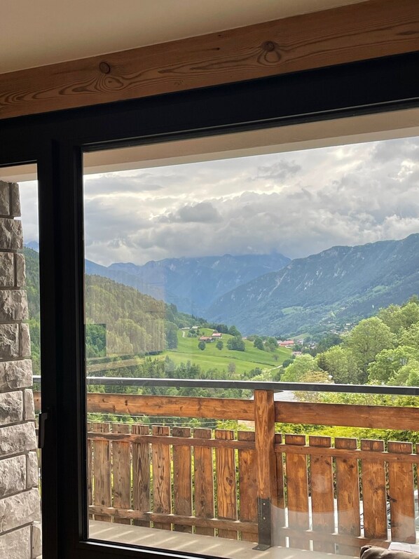A room with a large window offering a view of a mountainous landscape.