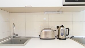 Eine moderne Küche mit Spüle aus Edelstahl, einem Kenwood-Toaster und einem Wasserkocher.
